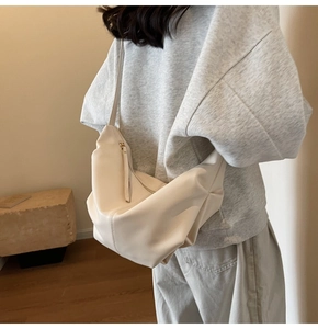 Borsa a tracolla minimalista in ecopelle bianco crema indossata da una modella in interno