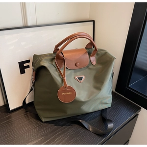 Détail du cabas en nylon vert olive avec poignées en cuir marron et étiquette