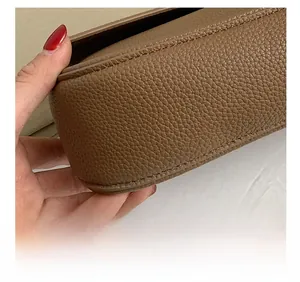 Dettaglio macro delle cuciture di precisione sulla borsa in pelle marrone martellata