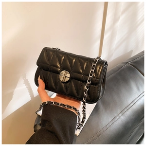Detail einer schwarzen gesteppten Lederhandtasche mit silbernem Drehverschluss