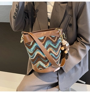Detail of vintage brown bucket bag with zigzag knit pattern and plush doll charm