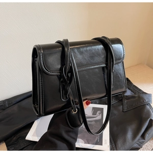 Detailed view of large capacity black shoulder bag with smooth leather texture and strap