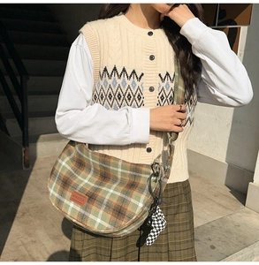 Détail du sac seau en nylon à carreaux avec logo en cuir et breloque en cœur