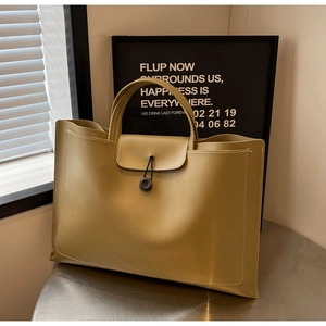 Detail view of mustard yellow tote bag with contrast stitching and button closure