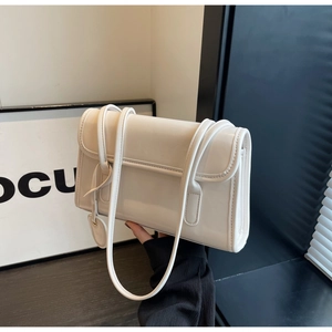 Detail of cream white glossy leather shoulder bag with fine straps and heart charm