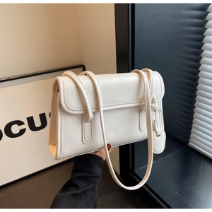 Detail of white rectangle underarm bag with double straps and heart-shaped pendant