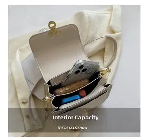 Detail of multi-compartment interior and capacity of beige leather crossbody bag