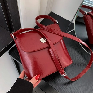 Glanzende donkerrode crossbody tas met zilveren m-gesp en verstelbare schouderriem