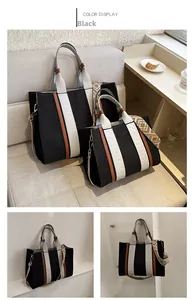 Détail de cabas en toile noire avec motifs rayés et large bandoulière style ethnique