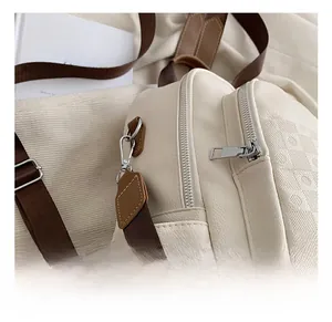 Détail du sac en cuir litchi blanc cassé avec sangle brune et crochets argentés