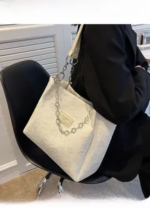 Détail du sac cabas blanc avec gaufrage floral 3D et bandoulière en chaîne argent