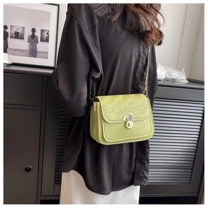 Detail of avocado green crossbody bag featuring cartoon embossing and rabbit ear metal lock