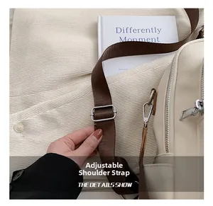 Gros plan sur la bandoulière réglable en nylon avec boucle argentée d'un sac en cuir beige