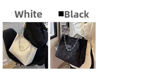 Détail des grands sacs cabas en tissu jacquard floral noir et blanc avec bandoulière chaîne