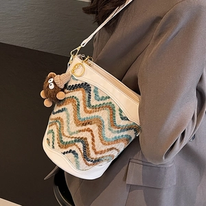 Chic knit bucket bag with wave patterns and white leather trim worn by a model