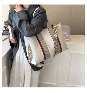 Détail du sac cabas en toile blanche avec bordure en cuir marron et bandoulière ethnique