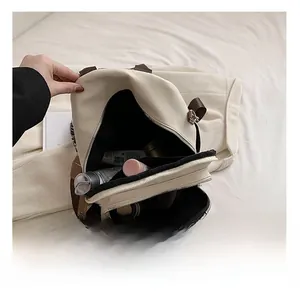 Détail de l'intérieur du grand sac à dos beige montrant les poches zippées et le stockage