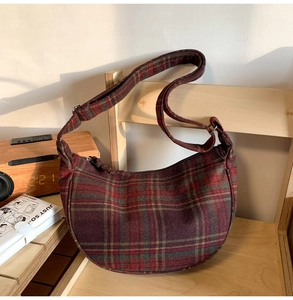 Détail d'un sac hobo à carreaux vintage rouge et vert avec bandoulière réglable