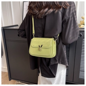Detail of light green PU leather crossbody bag with rabbit ear lock and floral embossing