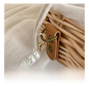 Detail shot of woven straw texture with white drawstring lining and elegant pearl strap