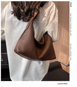 Detail of dark brown lychee leather hobo bag with adjustable strap and golden hardware
