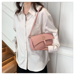 Borsa sottobraccio in pelle martellata rosa con fibbia dorata indossata da modella