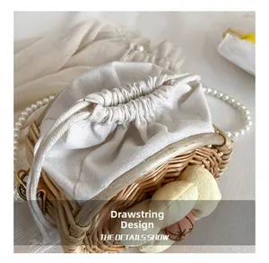 Detail of the woven straw bucket bag showing the drawstring design and soft canvas lining