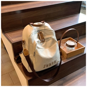 Détail du sac à dos en cuir blanc cassé avec motif matelassé et sangle bicolore brune
