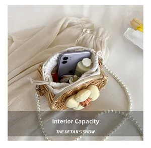 Internal capacity of the straw woven bag with pearl strap and floral accents