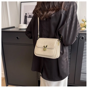 Detail of cream crossbody bag with rabbit ear lock and embossed loves pattern