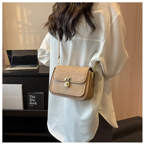 Detail of khaki PU leather crossbody bag with rabbit ear lock and embossed patterns