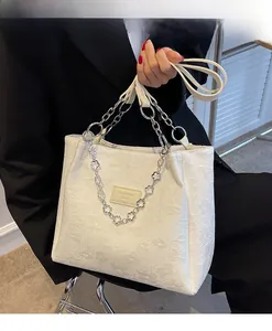 Grand sac cabas blanc avec texture florale en relief et détails de bandoulière en chaîne
