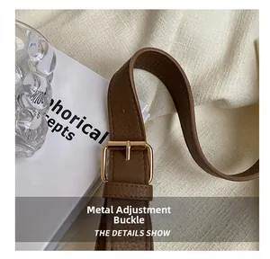 Detail of dark brown lychee leather strap with gold hardware adjustment buckle