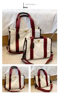 Detail view of large and small canvas tote bags with red striped handles and turn-lock
