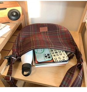 Vue intérieure spacieuse du sac hobo à carreaux bordeaux avec smartphone et bouteille