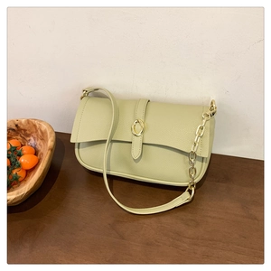 Dettaglio della borsa sottobraccio verde avocado in pelle martellata con fibbia oro