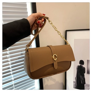 Dettaglio della pelle martellata marrone e fibbia dorata a goccia della borsa chic