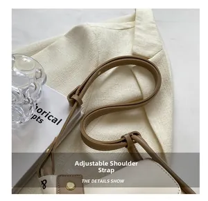 Adjustable brown leather shoulder strap detail on a stylish two-tone crossbody bag