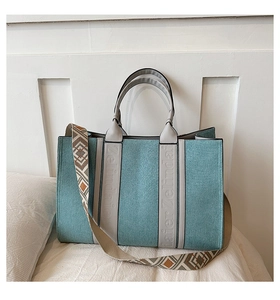 Détail du sac cabas bleu avec lanières en cuir gris et bandoulière à motifs