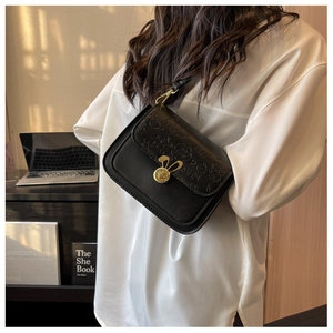 Detail of black faux leather crossbody bag with cartoon embossing and gold rabbit clasp