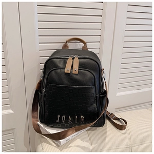 Détail d'un sac à dos en cuir noir avec poignées marron et logo métallique JOAIR