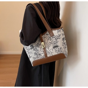 Detail view of retro canvas tote with floral rabbit print and brown leather accents