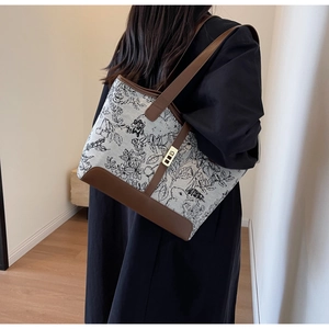 Detail of vintage floral canvas tote bag featuring brown leather trim and gold lock
