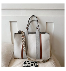 Détail du sac cabas en toile avec rayures et bandoulière ethnique colorée
