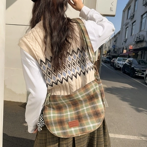 Sac seau chic en nylon à carreaux pour femme porté avec une tenue d'automne décontractée