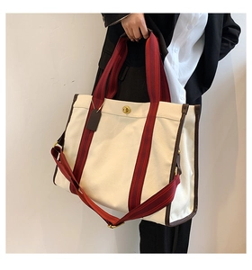 Detail of canvas tote bag with brown leather trim and striped detachable shoulder strap