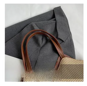 Détail du tissage en paille claire et de la poignée en cuir marron avec couture fine