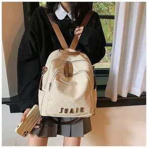 Détail du sac à dos de voyage beige avec texture à carreaux et logo JOAIR