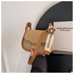Detail of khaki leather crossbody bag with metallic logo and textured fashion wide strap