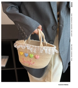 Detail of hand-held straw woven bag with lace trim, colorful hearts and pink embroidery